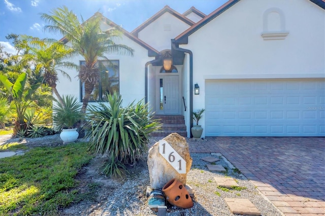 view of front of home with stucco siding, driveway, and a garage