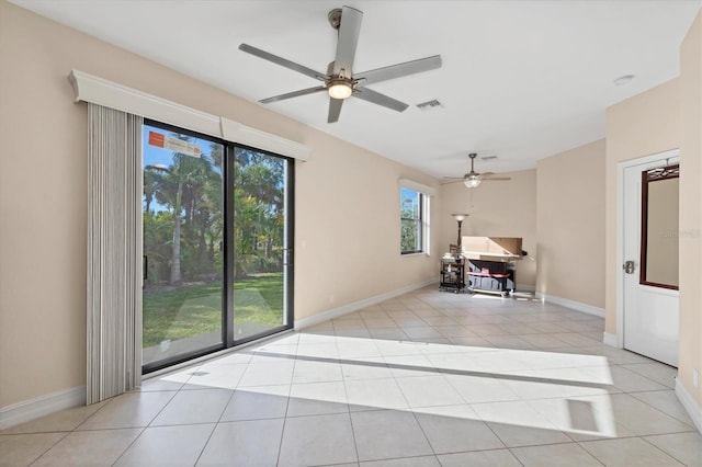 spare room with ceiling fan, light tile patterned flooring, and baseboards