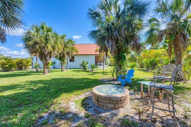 view of green lawn featuring a fire pit
