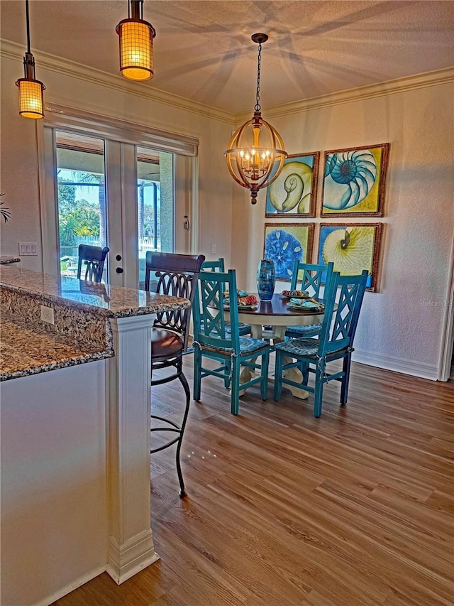 174 Broadmoor Ln, Rotonda West, FL 33947 - dining room with french doors, a chandelier, wood finished floors, and ornamental molding