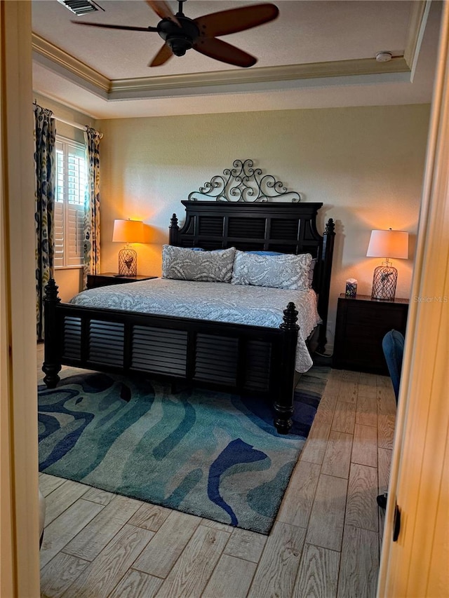 174 Broadmoor Ln, Rotonda West, FL 33947 - bedroom featuring a raised ceiling, ornamental molding, wood finished floors, and a ceiling fan