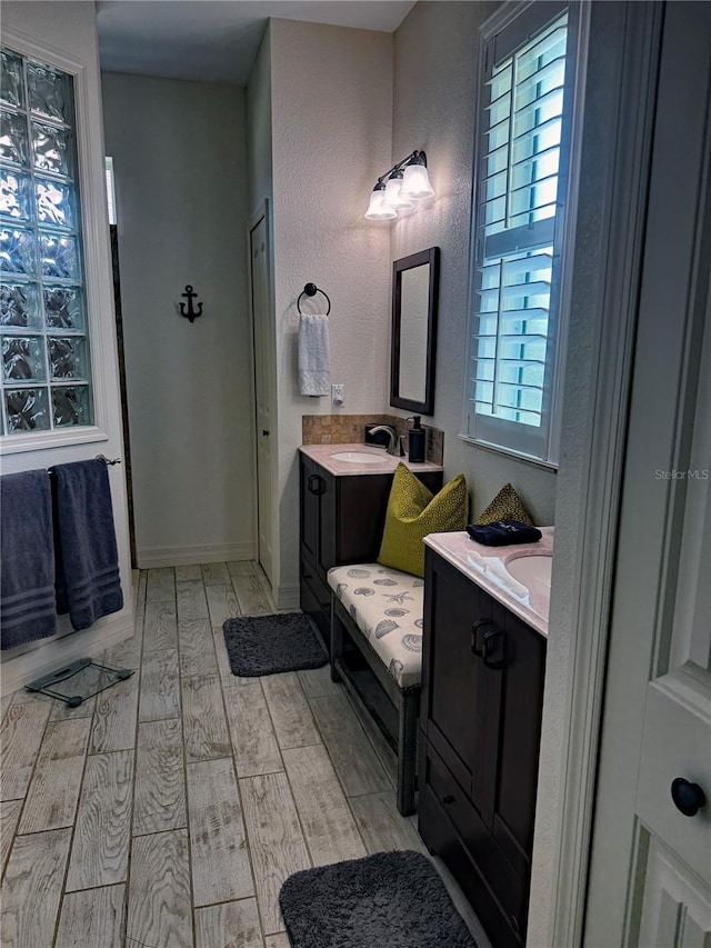 174 Broadmoor Ln, Rotonda West, FL 33947 - bathroom with healthy amount of natural light, wood finished floors, and two vanities
