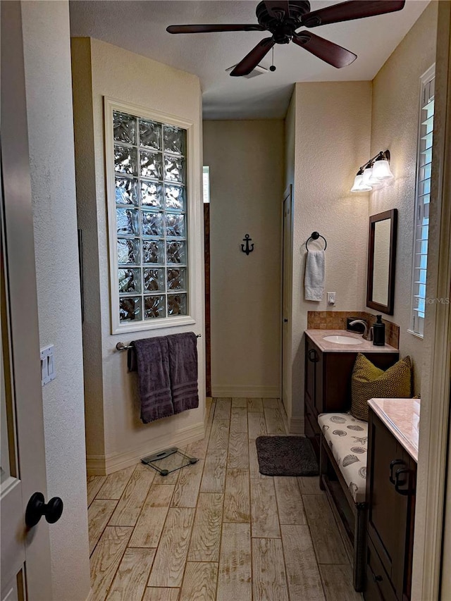 174 Broadmoor Ln, Rotonda West, FL 33947 - bathroom with hardwood / wood-style floors, a ceiling fan, a textured wall, and vanity