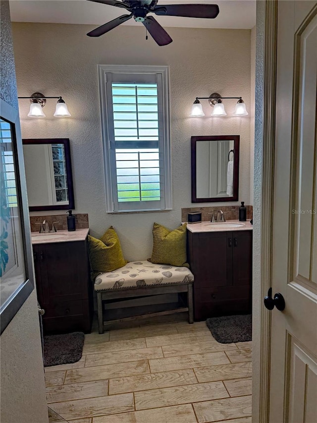 174 Broadmoor Ln, Rotonda West, FL 33947 - bathroom with wood finished floors, two vanities, ceiling fan, and a textured wall