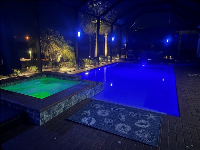 174 Broadmoor Ln, Rotonda West, FL 33947 - pool at twilight featuring an in-ground hot tub, an outdoor pool, glass enclosure, and a patio area