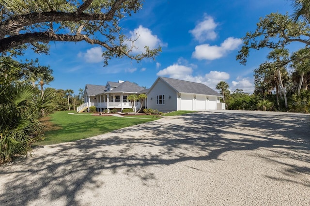 9144 Spring Valley Rd, Englewood, FL 34224 - view of front of property featuring driveway, a porch, a front lawn, and a garage