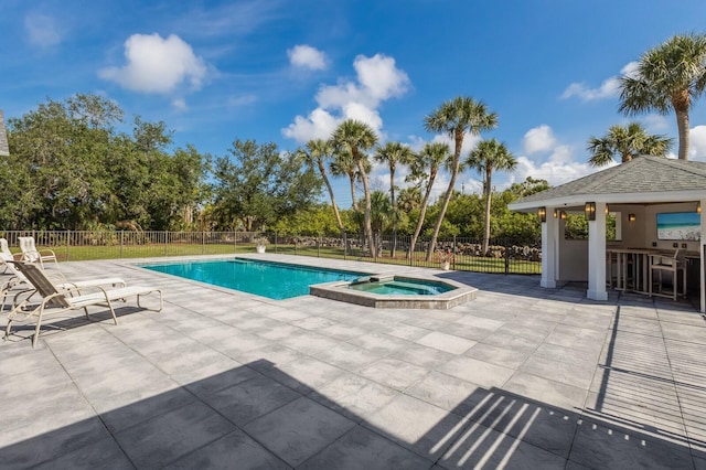 9144 Spring Valley Rd, Englewood, FL 34224 - view of swimming pool featuring a patio, fence, a pool with connected hot tub, and view of wooded area