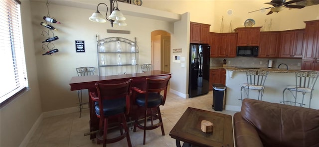 19 Medalist Way, Rotonda West, FL 33947 - kitchen with black appliances, arched walkways, and light tile patterned floors