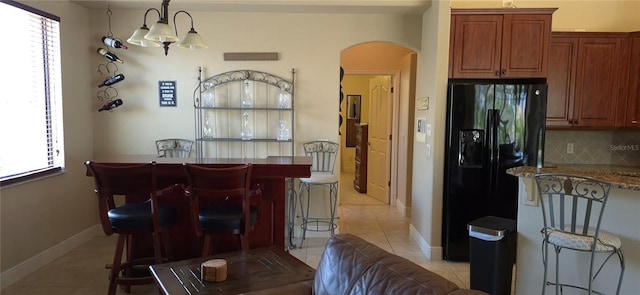 19 Medalist Way, Rotonda West, FL 33947 - dining area featuring arched walkways, light tile patterned floors, baseboards, and a bar