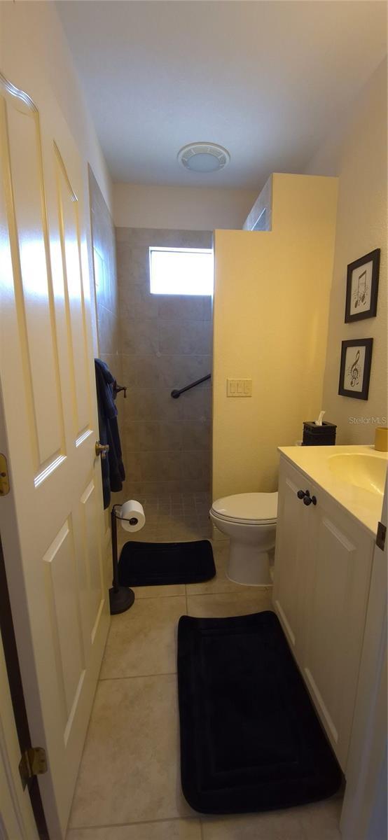 19 Medalist Way, Rotonda West, FL 33947 - full bathroom with tile patterned floors, a tile shower, vanity, and toilet