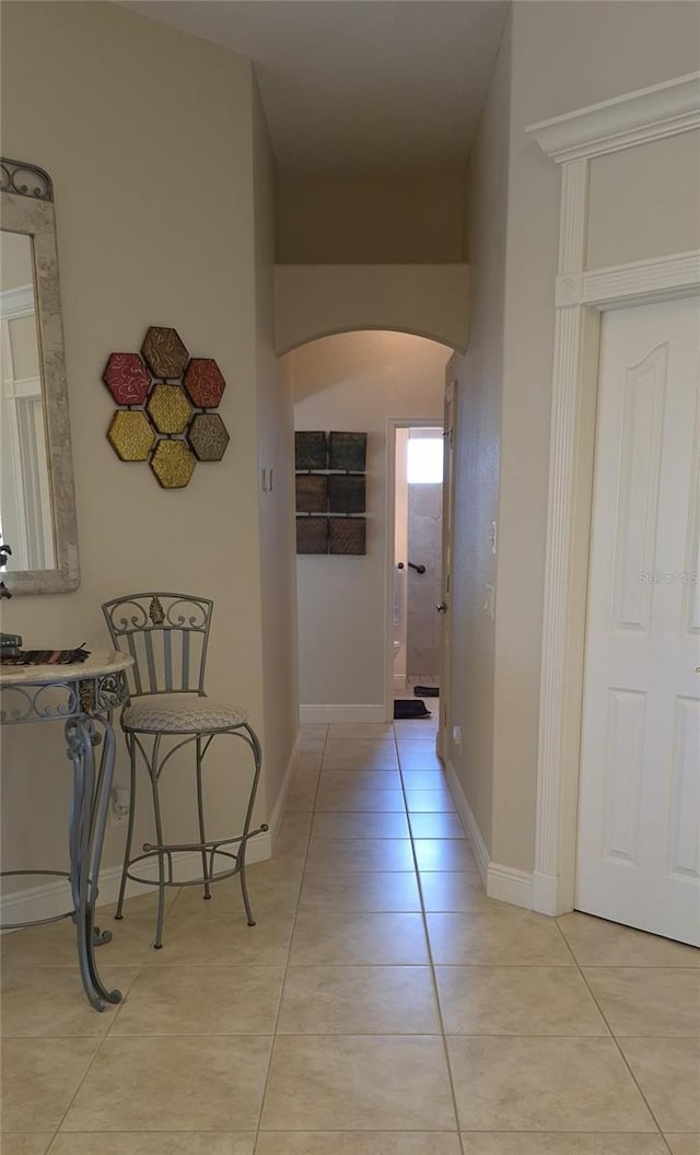 19 Medalist Way, Rotonda West, FL 33947 - hallway featuring arched walkways, light tile patterned flooring, and baseboards