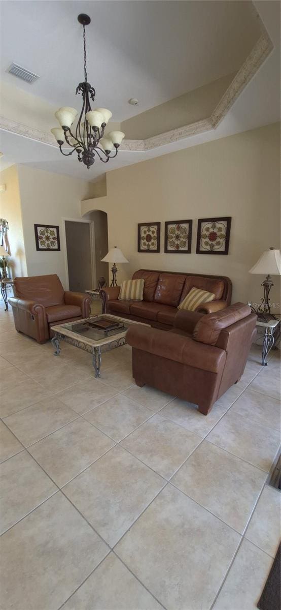 19 Medalist Way, Rotonda West, FL 33947 - living room with light tile patterned floors, a chandelier, a tray ceiling, and arched walkways