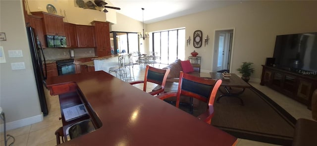 19 Medalist Way, Rotonda West, FL 33947 - dining area with ceiling fan, vaulted ceiling, baseboards, light tile patterned floors, and a chandelier