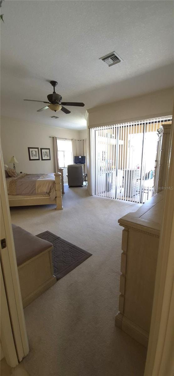 19 Medalist Way, Rotonda West, FL 33947 - bedroom with light colored carpet, access to exterior, and a ceiling fan