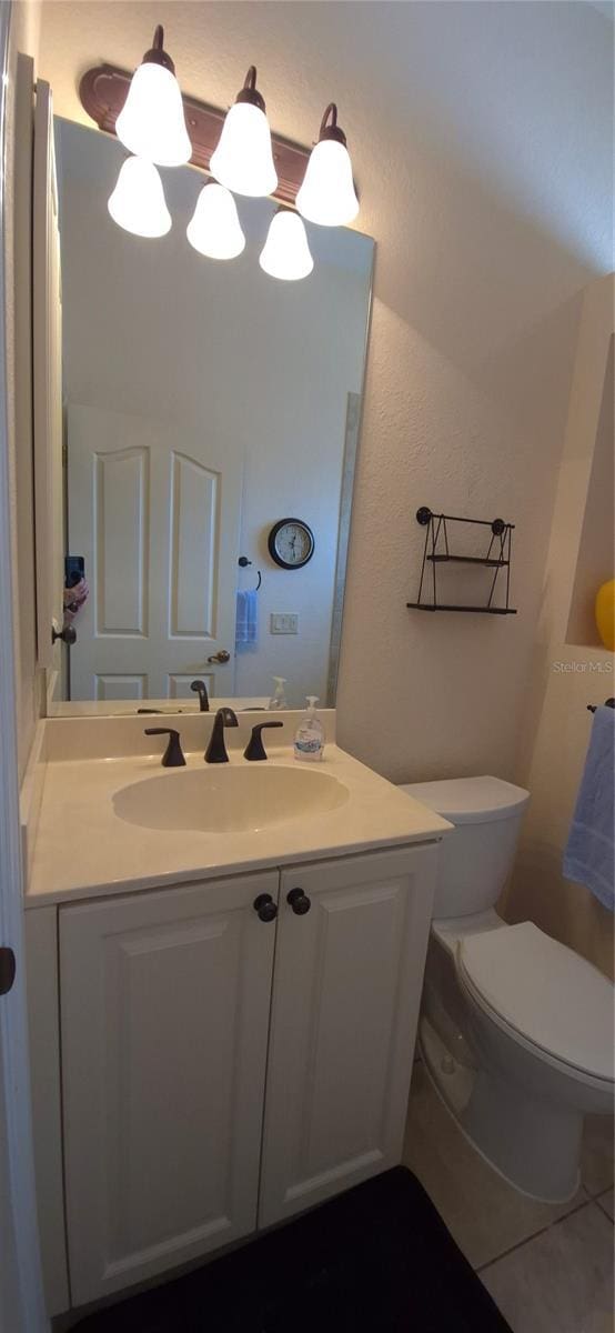 19 Medalist Way, Rotonda West, FL 33947 - bathroom featuring toilet, vanity, a textured wall, and tile patterned flooring