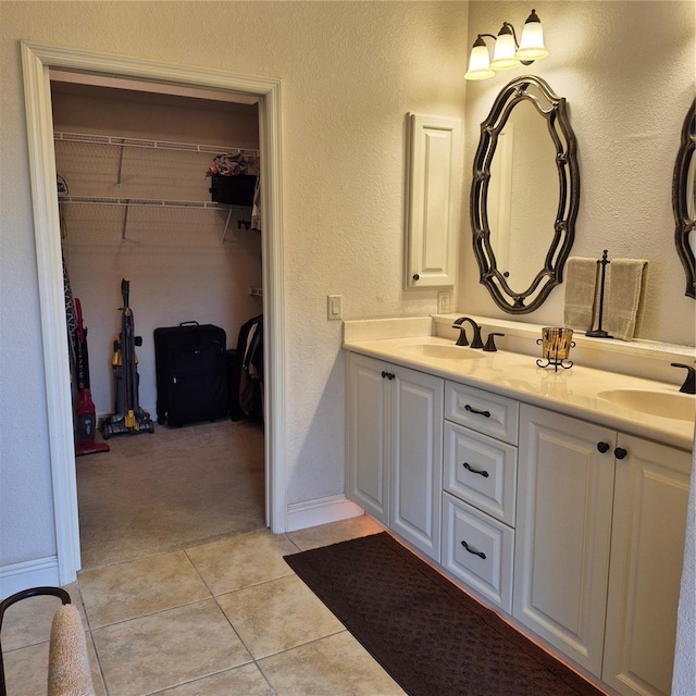19 Medalist Way, Rotonda West, FL 33947 - full bath with double vanity, tile patterned flooring, a walk in closet, and a textured wall