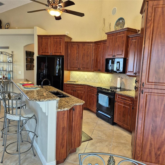 19 Medalist Way, Rotonda West, FL 33947 - kitchen with black appliances, a ceiling fan, backsplash, light stone counters, and a kitchen island with sink