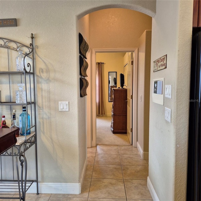 19 Medalist Way, Rotonda West, FL 33947 - hallway featuring arched walkways, light tile patterned floors, and a textured wall