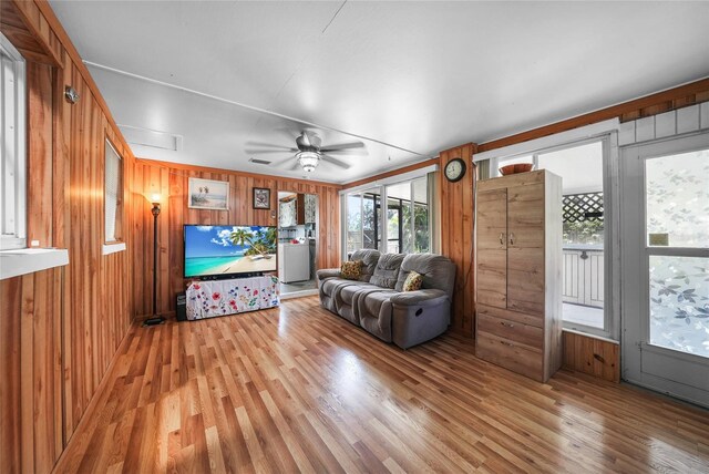 857 Palmetto St, Englewood, FL 34223 - living room with light wood-style floors, wooden walls, and a ceiling fan