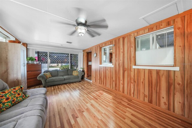 857 Palmetto St, Englewood, FL 34223 - living room featuring healthy amount of natural light, a ceiling fan, wood finished floors, and wood walls
