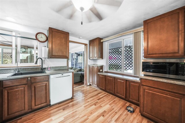 857 Palmetto St, Englewood, FL 34223 - kitchen with white dishwasher, a sink, stainless steel microwave, ceiling fan, and light wood finished floors