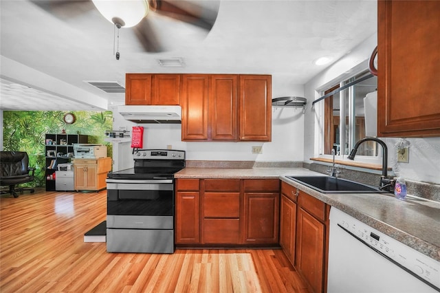857 Palmetto St, Englewood, FL 34223 - kitchen with white dishwasher, stainless steel electric stove, under cabinet range hood, a sink, and light wood-type flooring