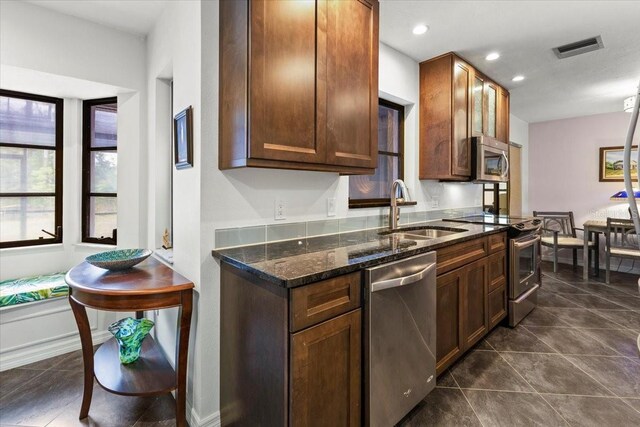 7180 Quarry St, Englewood, FL 34224 - kitchen with a sink, stainless steel appliances, dark tile patterned flooring, dark stone countertops, and recessed lighting