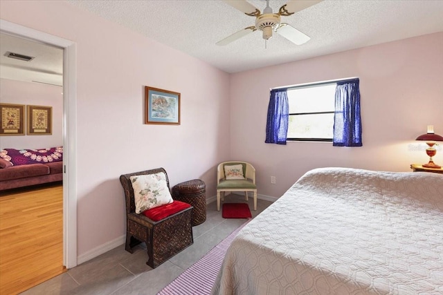 7180 Quarry St, Englewood, FL 34224 - bedroom featuring a textured ceiling, tile patterned flooring, a ceiling fan, and baseboards