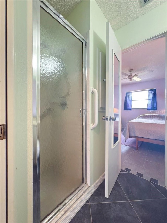 7180 Quarry St, Englewood, FL 34224 - bathroom with a textured ceiling, ensuite bathroom, tile patterned flooring, a shower stall, and a ceiling fan