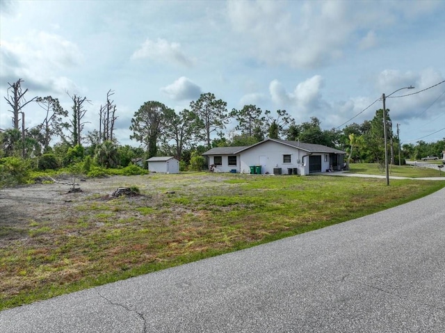 7180 Quarry St, Englewood, FL 34224 - view of front of home featuring an outbuilding, a front yard, driveway, and a storage shed