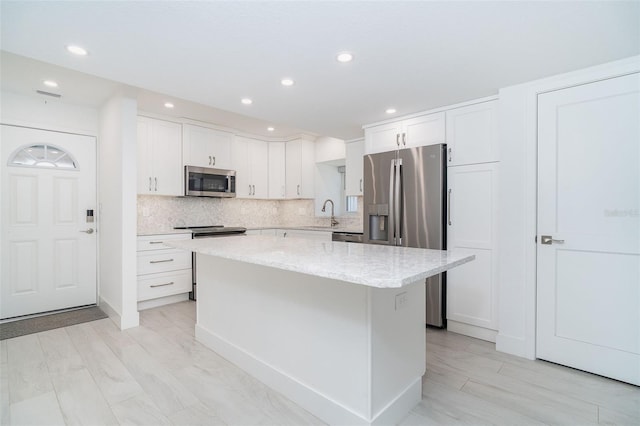 2700 N Beach Rd Unit A201, Englewood, FL 34223 - kitchen featuring stainless steel appliances, a kitchen island, recessed lighting, white cabinets, and tasteful backsplash