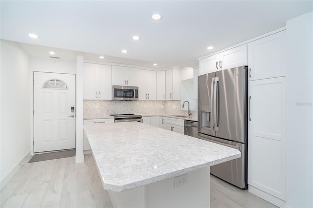 2700 N Beach Rd Unit A201, Englewood, FL 34223 - kitchen featuring stainless steel appliances, light countertops, white cabinetry, tasteful backsplash, and recessed lighting