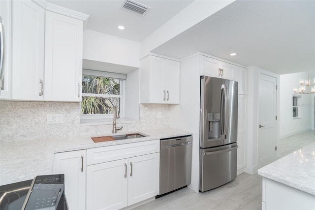 2700 N Beach Rd Unit A201, Englewood, FL 34223 - kitchen with appliances with stainless steel finishes, a sink, white cabinets, decorative backsplash, and recessed lighting
