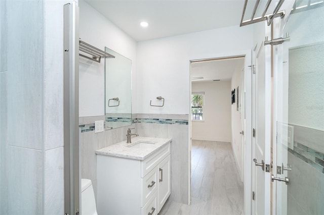 2700 N Beach Rd Unit A201, Englewood, FL 34223 - bathroom featuring toilet, vanity, tile walls, and recessed lighting