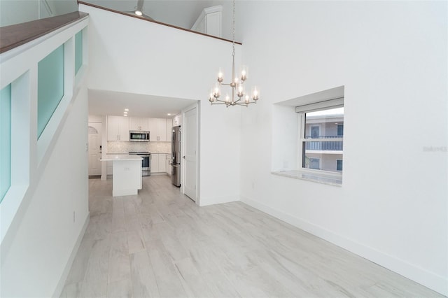 2700 N Beach Rd Unit A201, Englewood, FL 34223 - unfurnished dining area featuring a chandelier, baseboards, and a towering ceiling