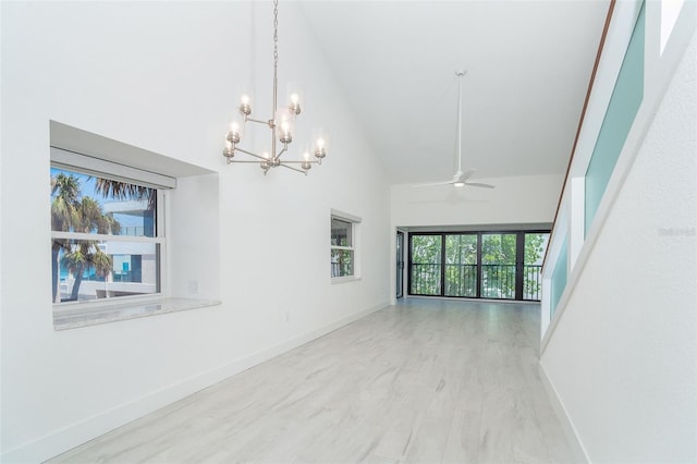 2700 N Beach Rd Unit A201, Englewood, FL 34223 - empty room with high vaulted ceiling, a ceiling fan, a chandelier, and baseboards