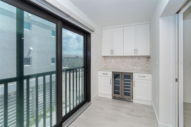 2700 N Beach Rd Unit A201, Englewood, FL 34223 - indoor dry bar with wine cooler, decorative backsplash, and baseboards