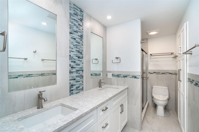 2700 N Beach Rd Unit A201, Englewood, FL 34223 - bathroom featuring tile walls, a shower stall, toilet, double vanity, and marble look tile flooring