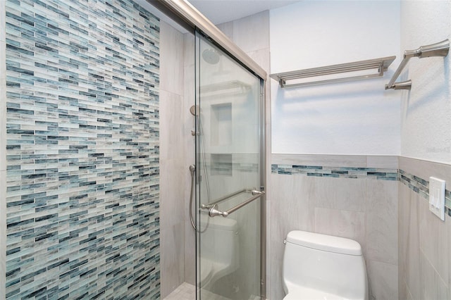 2700 N Beach Rd Unit A201, Englewood, FL 34223 - full bathroom with a stall shower, tile walls, and toilet