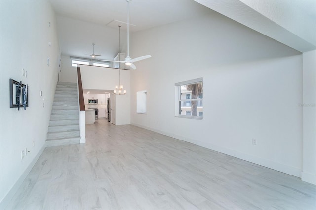 2700 N Beach Rd Unit A201, Englewood, FL 34223 - unfurnished living room with a high ceiling, a chandelier, ceiling fan, healthy amount of natural light, and baseboards