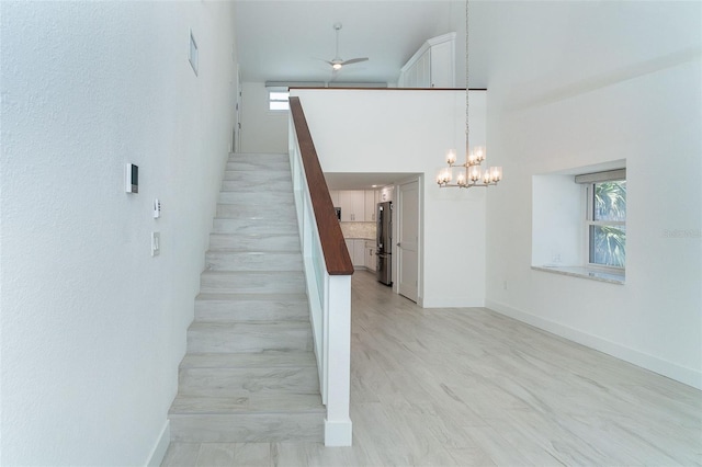 2700 N Beach Rd Unit A201, Englewood, FL 34223 - staircase with a chandelier, a ceiling fan, baseboards, and a high ceiling