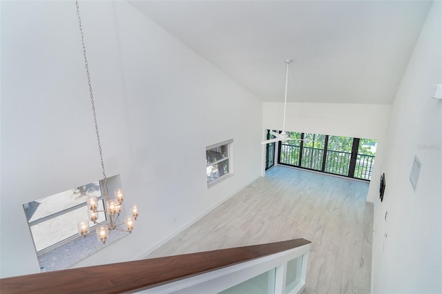 2700 N Beach Rd Unit A201, Englewood, FL 34223 - unfurnished living room featuring a chandelier, high vaulted ceiling, and baseboards