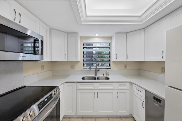 149 Englewood Isles Parkway Unit 603, Englewood, FL 34223 - kitchen with appliances with stainless steel finishes, a sink, a raised ceiling, white cabinets, and light countertops
