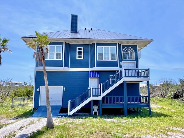 9594 Doubloon Trl, Placida, FL 33946 - rear view of property with stairs, an attached garage, a chimney, metal roof, and fence
