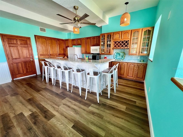 9594 Doubloon Trl, Placida, FL 33946 - kitchen with white appliances, dark wood-style flooring, a kitchen breakfast bar, and a spacious island