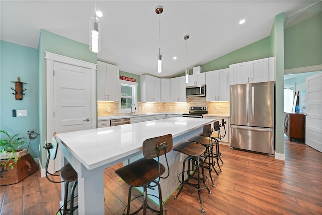 171 Mark Twain Ln, Rotonda West, FL 33947 - kitchen featuring stainless steel appliances, tasteful backsplash, lofted ceiling, a kitchen breakfast bar, and white cabinetry