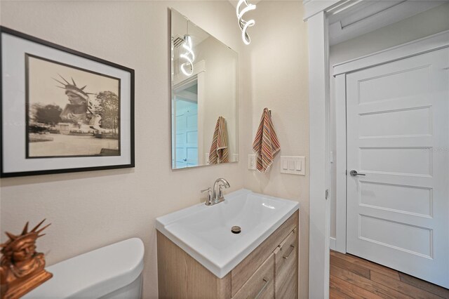 171 Mark Twain Ln, Rotonda West, FL 33947 - bathroom with vanity, wood finished floors, and toilet