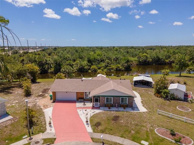 view of subject property with a heavily wooded area and a nearby body of water