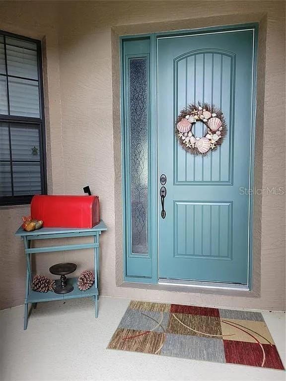 142 Yellow Pine Dr, Rotonda West, FL 33947 - view of exterior entry featuring stucco siding