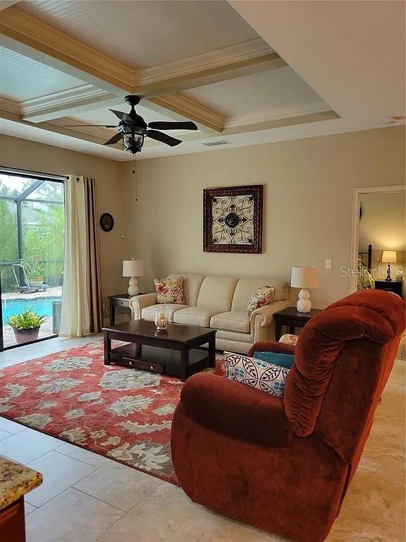 142 Yellow Pine Dr, Rotonda West, FL 33947 - living area with coffered ceiling, a ceiling fan, beam ceiling, light tile patterned flooring, and crown molding